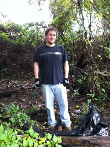 Chad cleaning trash along bank of Herring Run Creek