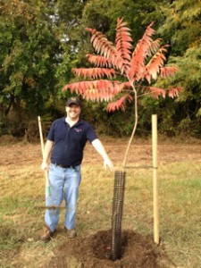 Charles Wagner stands next to planted tree