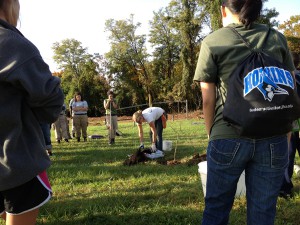 Debra Lenik instructs volunteers on how to plant a tree properly